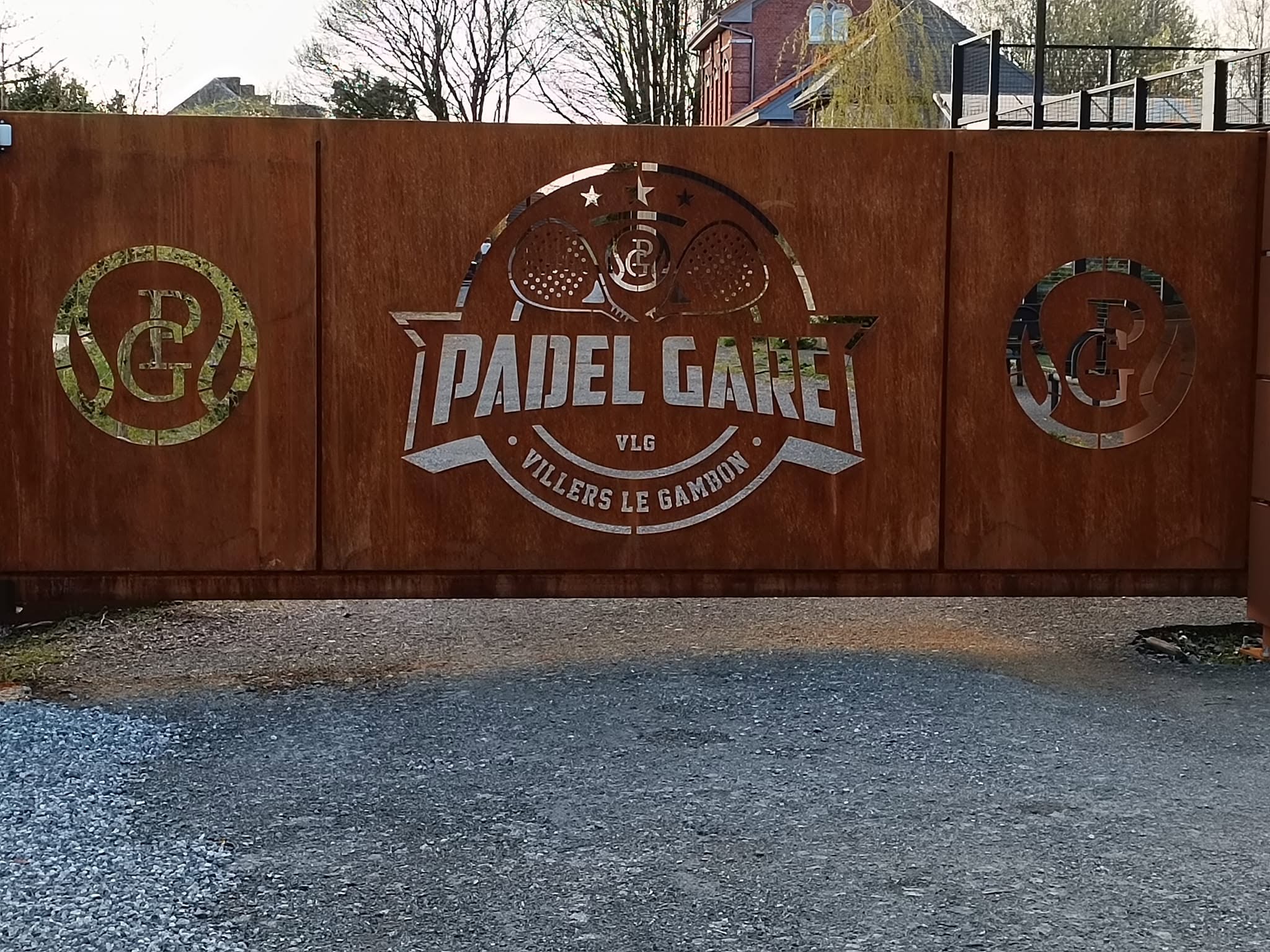L'enseigne en acier corten du Padel Gare, à l'entrée du club